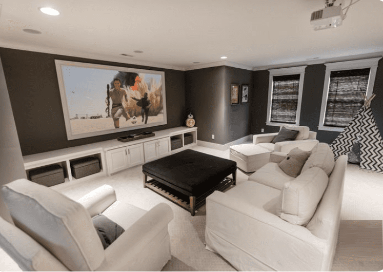 Home theater with large screen and comfy seating.