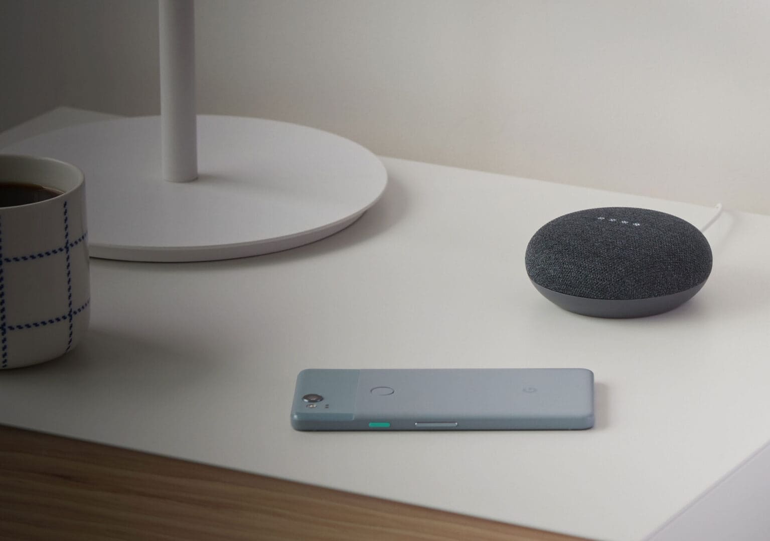 Google Home, Pixel phone, bedside table.